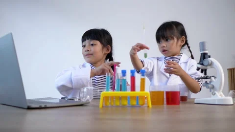 Slow motion shot, Two asian siblings wearing coat use laptop computer  Stockbeeldmateriaal 172193624