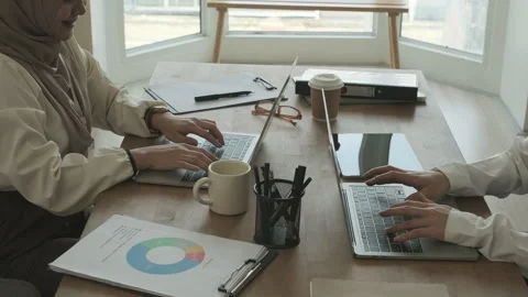 Slow motion shot of two female colleagues using laptop computer, working Stock Footage 254490671