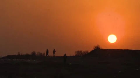 Slow motion shot of two person standing in front of sunset Stock Footage 252121006