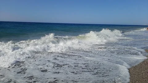 Slow motion shot video of foaming waves crashing noisily on a sandy beach on the Stock Footage 289413206