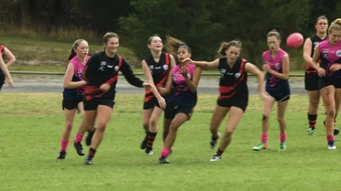 Slow-motion shot of WAFL U16 girls playing in the rain. Stock Footage 93264031