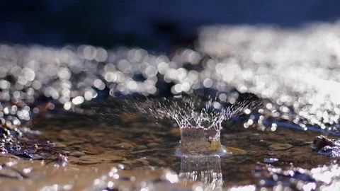 Slow motion shot of water dripping into puddle Stock Footage 89916100