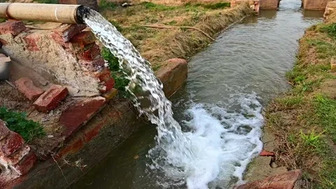 Slow motion shot of Water flow through big pump tube in wheat field. 4k Stock Footage 197590889