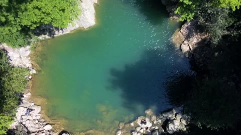 Slow motion shot of a waterfall from a drone top view of a beautiful pool of Stock Footage 235339234