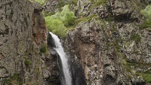 Slow motion shot of waterfall flowing down the rock. Camera moving down Stock Footage 114404380
