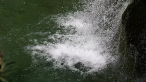Slow motion shot of a waterfall hitting the surface and kicking up spray Stock Footage 305032556