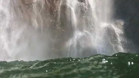 Slow-motion shot of a waterfall from within the water, surface dancing wild Stock Footage 248075019