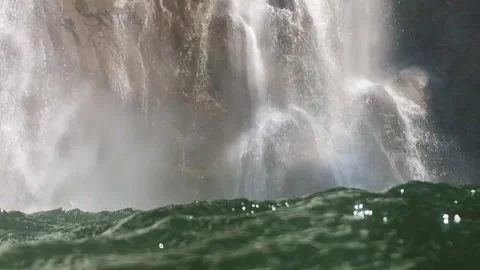 Slow-motion shot of a waterfall from within the water, surface dancing wild Stock Footage 248379084