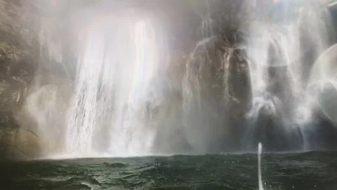Slow-motion shot of a waterfall from within the water, surface dancing wild Video stock 248379147