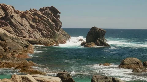 Slow Motion shot of waves crashing against rocky shoreline Stock Footage 305524313