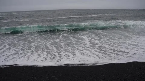 Slow motion shot of waves washing against Reynisfjara Black Sand Beach Stock Footage 247368257