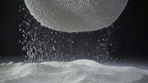 Slow motion shot of white cake flour falling through a metal sieve Stock-Footage 74009528