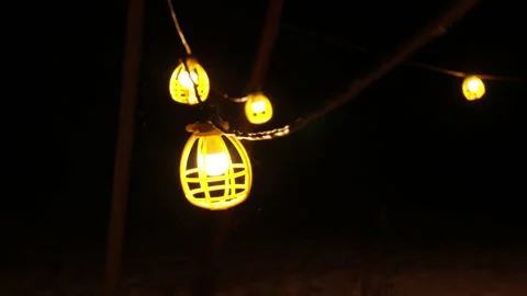 Slow motion shot of work light string swinging in snow storm Stock Footage 147330537