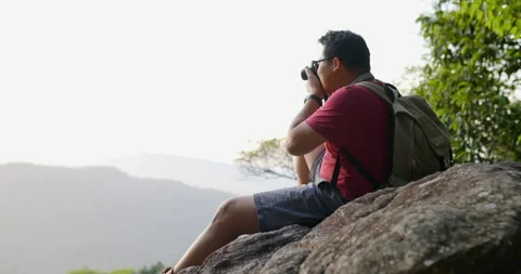 Slow motion shot, Young backpacker man in eyeglasses use digital  Stockbeeldmateriaal 198305983