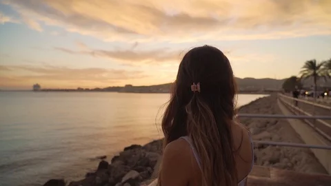 Slow motion shot of a young beautiful girl enjoying sunset and smiling while  스톡 동영상 129043589