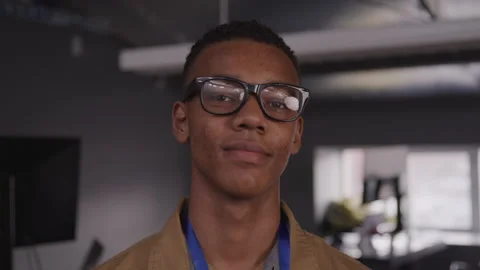 Slow motion shot of young black tech guy smiling at camera in office Stock Footage 208778140