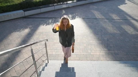 Slow motion shot of a young blonde business woman walking up stairs Vídeo Stock 333039640