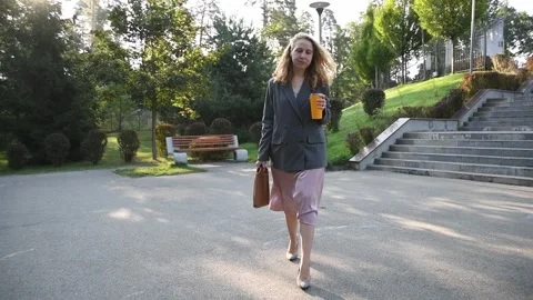 Slow motion shot of a young blonde woman walking through a park Vídeo Stock 333058509