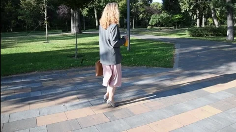 Slow motion shot of a young blonde woman walking through a park Vídeo Stock 333070239