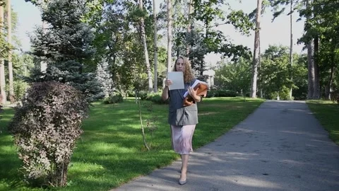 Slow motion shot of a young blonde woman walking through a park Video stock 333070638