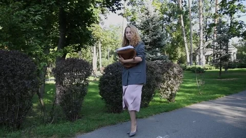 Slow motion shot of a young blonde woman walking through a park Vídeos de archivo 333070639