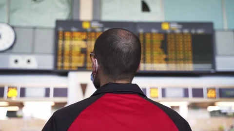 Slow motion shot of young man looking at airport panel Stock Footage 169937127