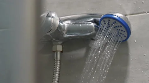 Slow Motion Shower head in bathroom, water is flows, shower door closes Video stock 212946076