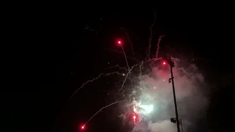Slow motion shows fireworks exploding and sparkling over baseball stadium Stock Footage 300709736