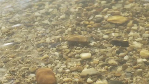 Slow motion sht at the beach with rocks waving water Stock Footage 71327408
