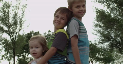 Slow Motion Siblings Posing Together with Trees in the Background Stock Footage 61652126