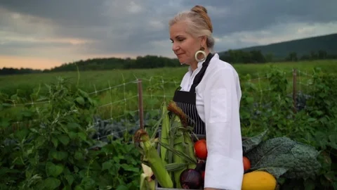 Slow motion side closeup shot of chef farmer walking through field carrying Stock Footage 136008507
