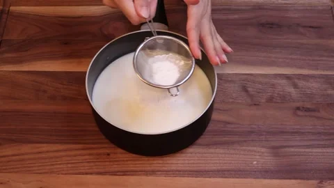 Slow Motion Sifting Cornstarch Into Hot Milk and Whisking in Saucepan Видео 334811482