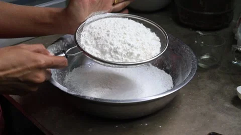 Slow motion of  sifting white flour by sieve in bowl. Stock Footage 134309040