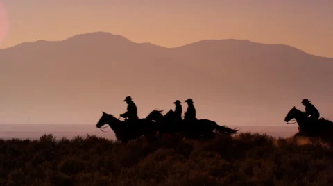 Slow motion silhouette shot of group of cowboys riding horses. Stock Footage 52258614