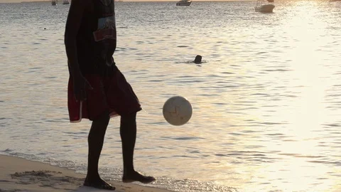 SLOW Motion, Silhouettes of young friends playing beach football at sunset Video stock 87699323