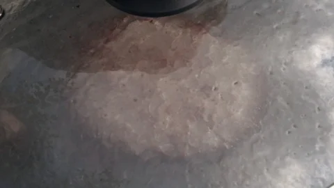 Slow motion of sizzling hamburger on dark gray fry pan with glass lid close up. Stock Footage 99854671