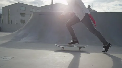 SLOW MOTION: Skateboarder jumps on his skate and starts cruising Stock Footage
