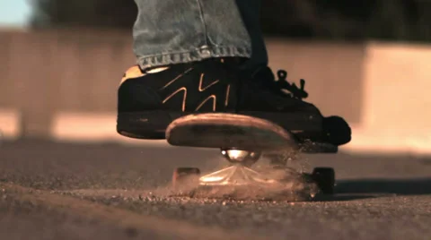 Slow motion skateboarding slide through dust/dirt Stock Footage