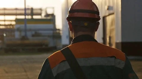 Slow Motion Skilled Worker Walks along Huge Refinery Territory Stock Footage 81052733