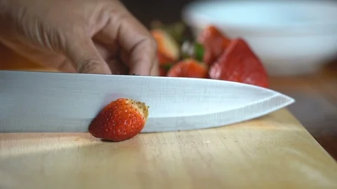 Slow motion, Slice fresh strawberries into pieces with a knife slowly. Stock Footage 94662142