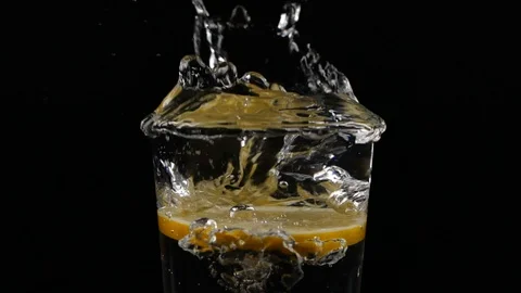 Slow motion of slice of lemon fruit splashing in a water glass with soda Video stock 123510754