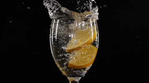 Slow motion of slice of lemon fruit falling down in a water glass with soda Vídeos de archivo 123510783