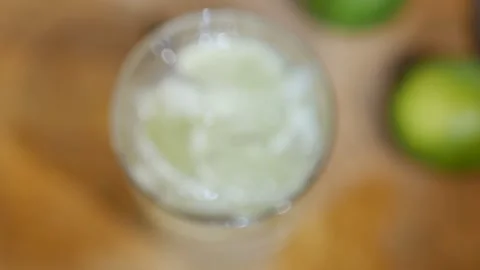Slow motion of slice of lime in a glass of sparkling soda water. Macro close-up, Stock Footage 143781438