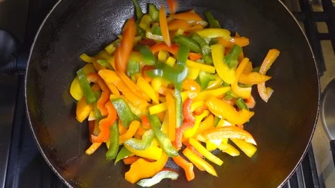 Slow motion - Sliced peppers being tipped from a bowl into a pan. Stock Footage 101956243
