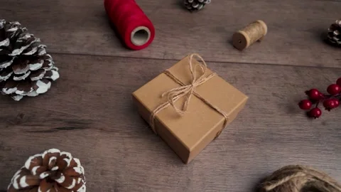 Slow motion slide right capturing gift box and rustic decorations on wooden.. Video stock 321545229