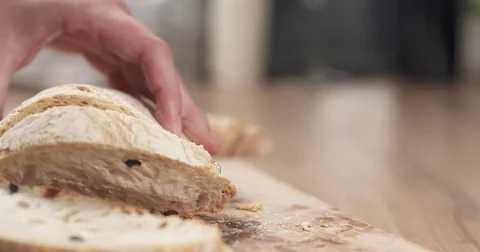 Slow motion slide shot of young female hands slicing ciabatta with olives on Stock Footage
