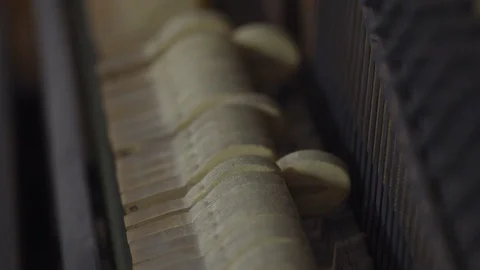 SLOW MOTION SLIDER OVER HAMMERS HITTING STRINGS IN AN UPRIGHT PIANO Stock Footage 126418605