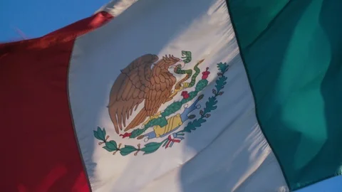 Slow motion: A slightly worn Mexican flag flies at border crossing Stock Footage 113232638
