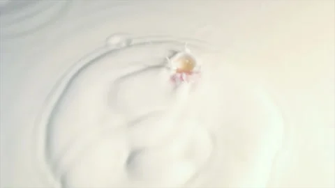 Slow motion with a small ball falling in milk. 库存影片 145349899
