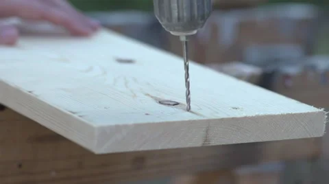 Slow Motion small drill bit drills into wooden board Video stock 68344967